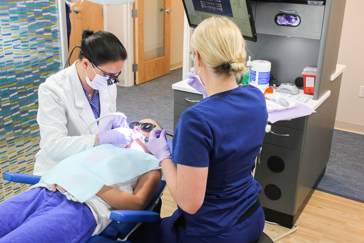 Dr. and assistant working on a patient's teeth