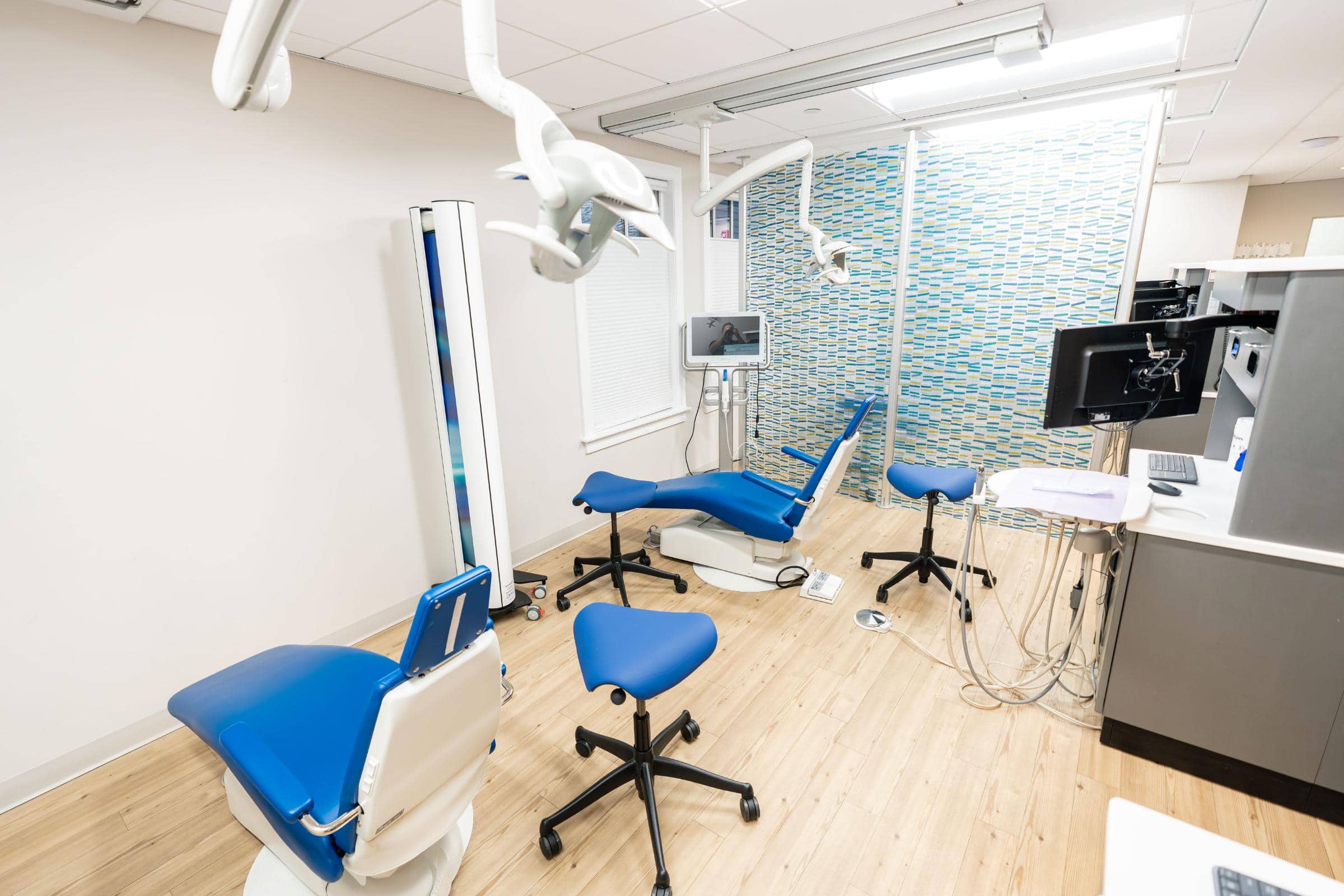 Dental treatment room at Coppe & Sears Orthodontics featuring blue dental chairs, modern equipment, and a bright, clean environment for Botox and orthodontic procedures.