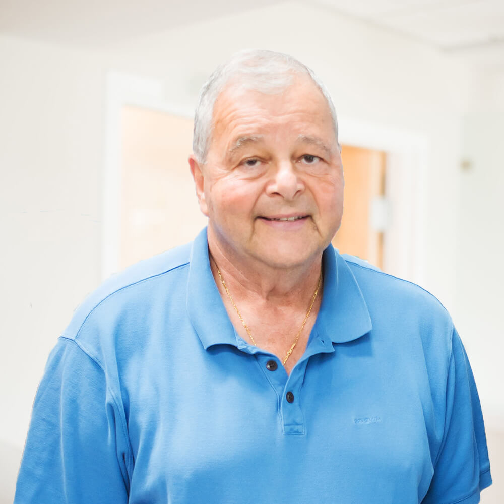 Dr. Michael Coppe, pediatric dentist in Lexington, MA, smiling in a dental office setting, representing Coppe + Sears pediatric dentistry and orthodontics.